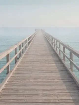 Wooden pier extending into calm open water, conveying structured progression in enterprise cybersecurity consultancy.